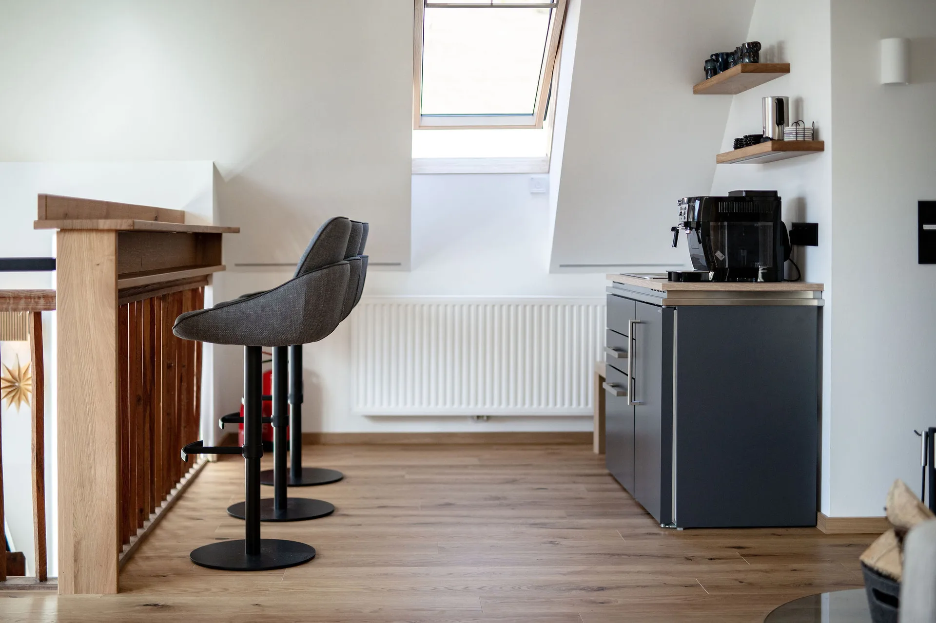 Bar mit Teeküche im Dachgeschoss mit Kaffeemaschine, Geschirrspüler, Kühlschrank und Bergblick.