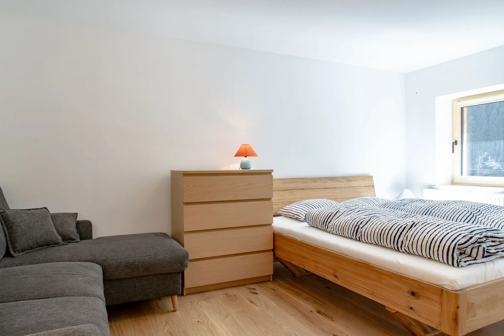 Hofseitiges Schlafzimmer mit 1.60m Doppelbett und Couch im 1. Stock.